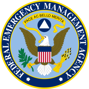 FEMA seal. The United States Eagle holds a ribbon in its beak featuring the latin phrase "pace ac bello merita'