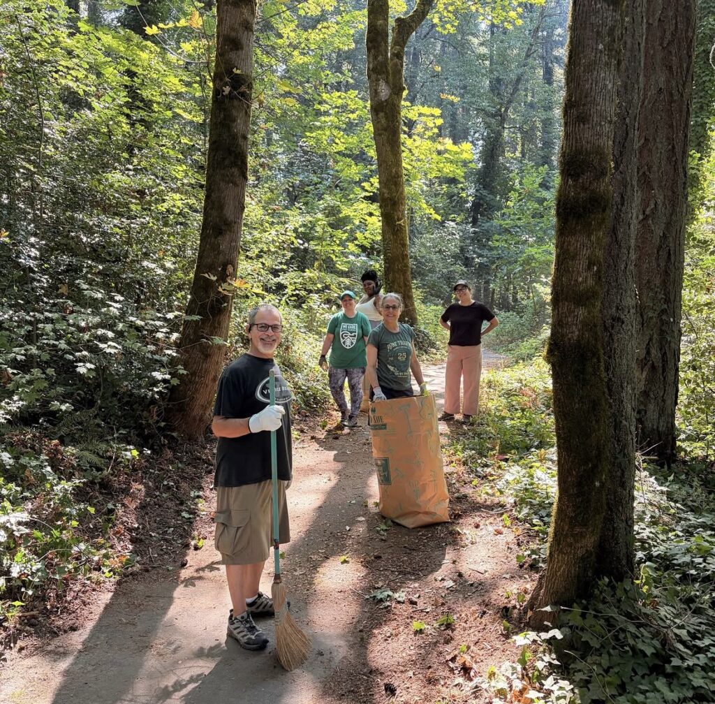 Volunteers pose with a bag of collected English Ivy