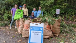Volunteers pose with bags of removed tree ivy after the event